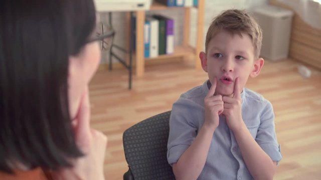 Close-up of a speech therapist deals with a little boy