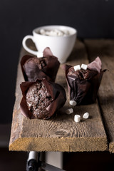 Three Tasty Chocolate Muffins on Wooden Tray White Cup of Cococa with Marshmallow Dark Photo Vertical