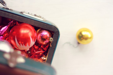 Christmas tree decorations in open retro suitcase top view. winter holidays coming soon