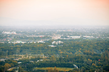 Blurry high angle nature background, which can see distant views (houses, mountains, trees, roads). The atmosphere is surrounded by the wind blowing through, seen at the natural viewpoint on the way.