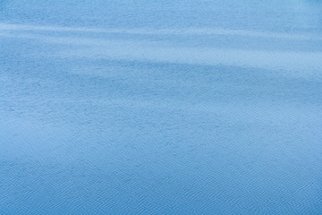 Blue background. Small ripples on the water.