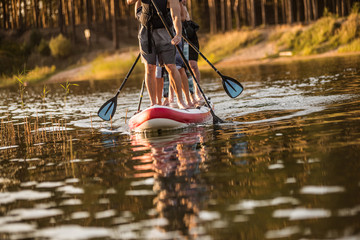 People driving on water with SUP board on a summer day