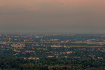 Blurry high angle nature background, which can see distant views (houses, mountains, trees, roads). The atmosphere is surrounded by the wind blowing through, seen at the natural viewpoint on the way.