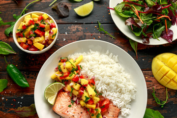 Salmon with mango salsa and white rice on plate