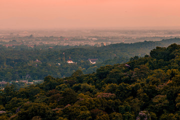 Blurry high angle nature background, which can see distant views (houses, mountains, trees, roads). The atmosphere is surrounded by the wind blowing through, seen at the natural viewpoint on the way.