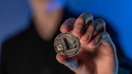 man holds cryptocurrency coin in his hands
