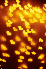 Abstract background with a golden blurred lights in heart shape. Valentine day concept