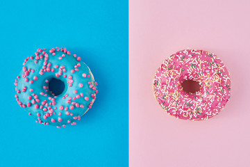 Two donuts on a pastel pink and blue background. Minimalism creative food composition. Flat lay...