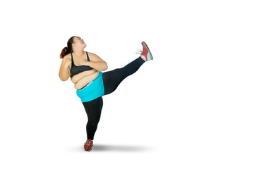 Fat Asian woman kicking the air with her left leg