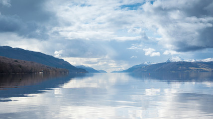 A view across Loch Ness looking down the length of the lake, with dark clouds above, in Scotland, UK