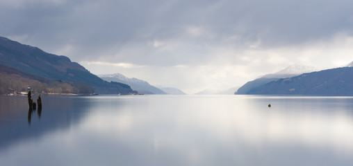 A view across Loch Ness looking down the length of the lake, with dark clouds above, in Scotland, UK