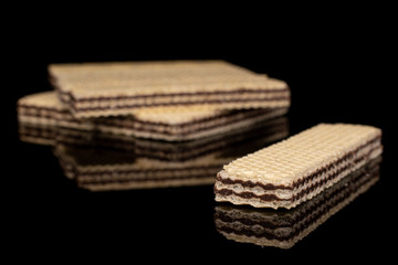 Lot of whole crispy sweet chocolate biscuit wafer isolated on black glass