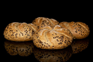 Group of four whole sesame kaiser roll isolated on black glass