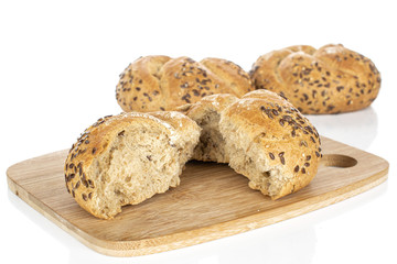 Group of two whole two halves of sesame kaiser roll on bamboo cutting board isolated on white background