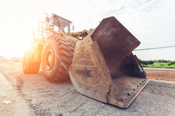Grader leveling gravel on road construction site © nikomsolftwaer