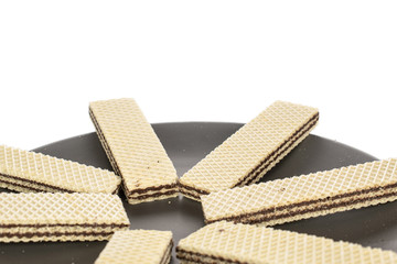 Group of seven whole sweet chocolate biscuit wafer closeup on gray ceramic plate isolated on white background