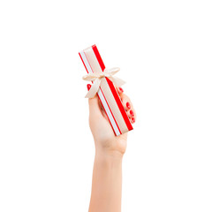 Woman hands give wrapped Christmas or other holiday handmade present in red paper with gold ribbon. Isolated on white background, top view. thanksgiving Gift box concept