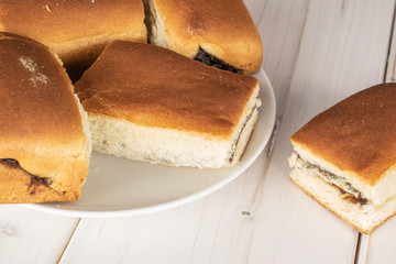 Group of five whole sweet czech bun on white ceramic plate on white wood