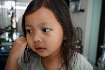 Portrait of a little girl with a hesitating facial expression