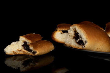 Group of four whole sweet czech bun on gray ceramic plate isolated on black glass