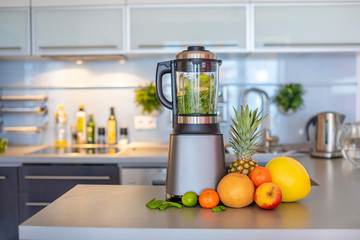 Making green smoothies with blender in home kitchen, healthy eating lifestyle concept