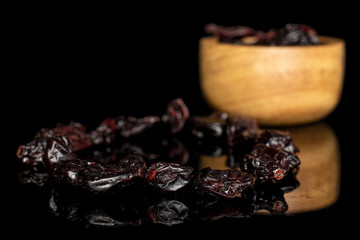 Lot of whole dried cowberry................ in bamboo bowl isolated on black glass