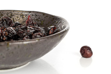 Lot of whole sweet dried cowberry................ in glazed bowl isolated on white background