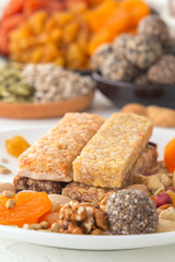 Bars of sports nutrition from nuts, seeds and chocolate paste - vegetable natural protein on the background of mix of dried fruits. Close-up