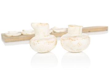 Group of two whole four slices of fresh white champignon on wooden cutting board isolated on white background