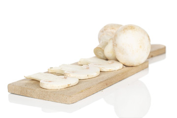 Group of two whole three slices of fresh white champignon on wooden cutting board isolated on white background