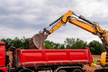 Bagger ladet Erde in den Kipper