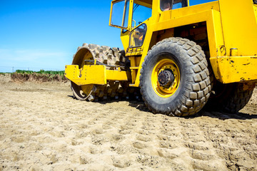 Road roller with spikes is working at construction site