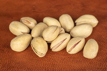 Obraz premium Lot of whole salted pistachio on cognac leather
