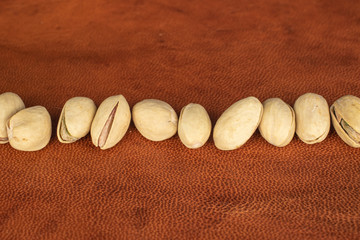 Lot of whole salted pistachio on cognac leather