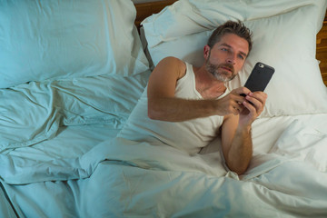 domestic lifestyle high angle portrait of young attractive and relaxed man at home lying on bed...