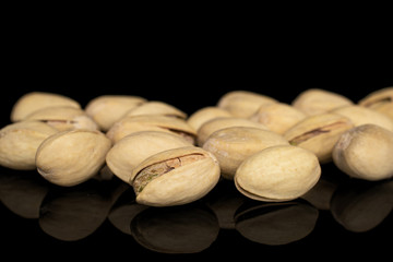 Obraz premium Lot of whole salted pistachio heap isolated on black glass