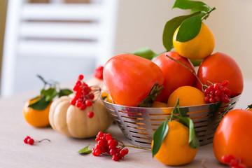 Food. Tangerines, viburnum, pumpkin, persimmon in table
