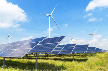 solar cells with wind turbines generating electricity in hybrid power plant systems station on blue sky background alternative renewable energy from nature  Ecology concept.   