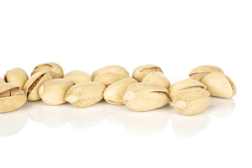 Lot of whole salted pistachio in row isolated on white background