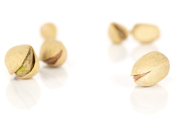 Group of six whole salted pistachio isolated on white background