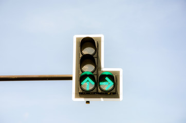 Green traffic light with blue sky background.