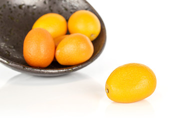 Group of five whole tasty orange kumquat in glazed bowl isolated on white background