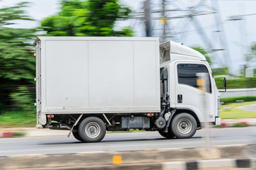 Fototapeta na wymiar Motion,small white truck for logistics on the road.
