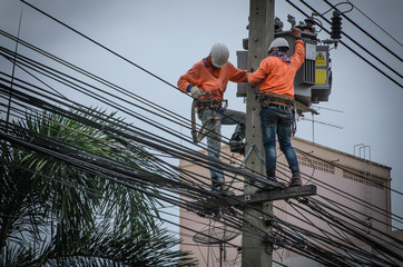 Technicians are repairing high voltage transmission systems on the power poles.