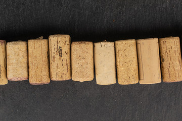 Lot of whole common wine cork line flatlay on grey stone