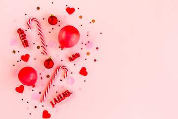 Confetti, balloons, streamers and decoration on a pink background. Colorful celebration, birthday background.Christmas or New Year pattern. Flat lay, top view 