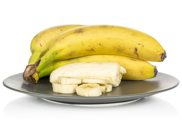 Group of three whole one half five slices of sweet yellow banana on gray ceramic plate isolated on white background