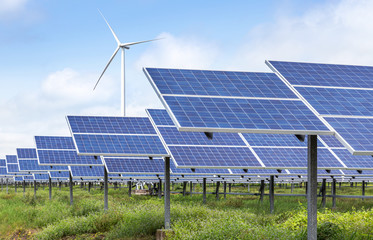 solar cells with wind turbines generating electricity in hybrid power plant systems station on blue...