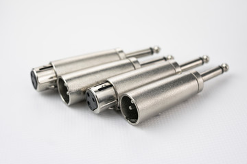 Close-up of metal male and female xlr audio converters to jack type, on white background