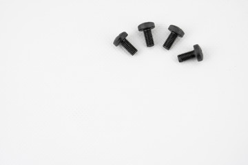 Black metal screws arranged in semicircle on white background